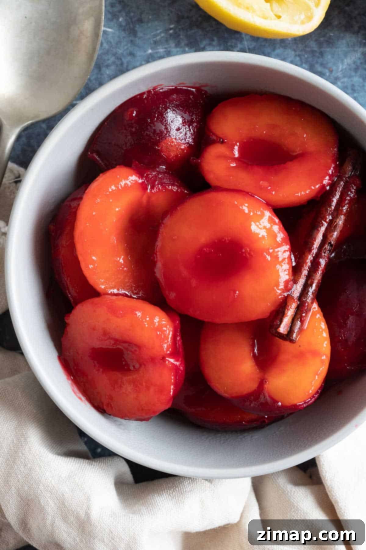 Εύκολη Κομπόστα Δαμάσκηνων 5 Stewed plums with cinnamon stick in a bowl.