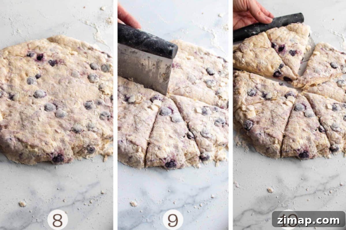 Προζυμένια Μύρτιλα Σκόουνς 6 A disc of sourdough scone dough and a bench scraper cutting it into triangles.