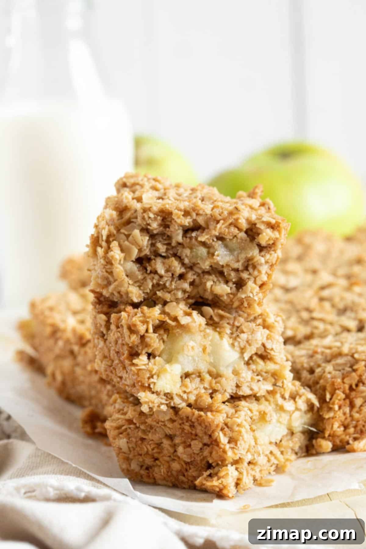 Εύκολες Μηλόμπάρες Βρώμης 2 Μια στοίβα από flapjacks μήλου με ένα ποτήρι γάλα.