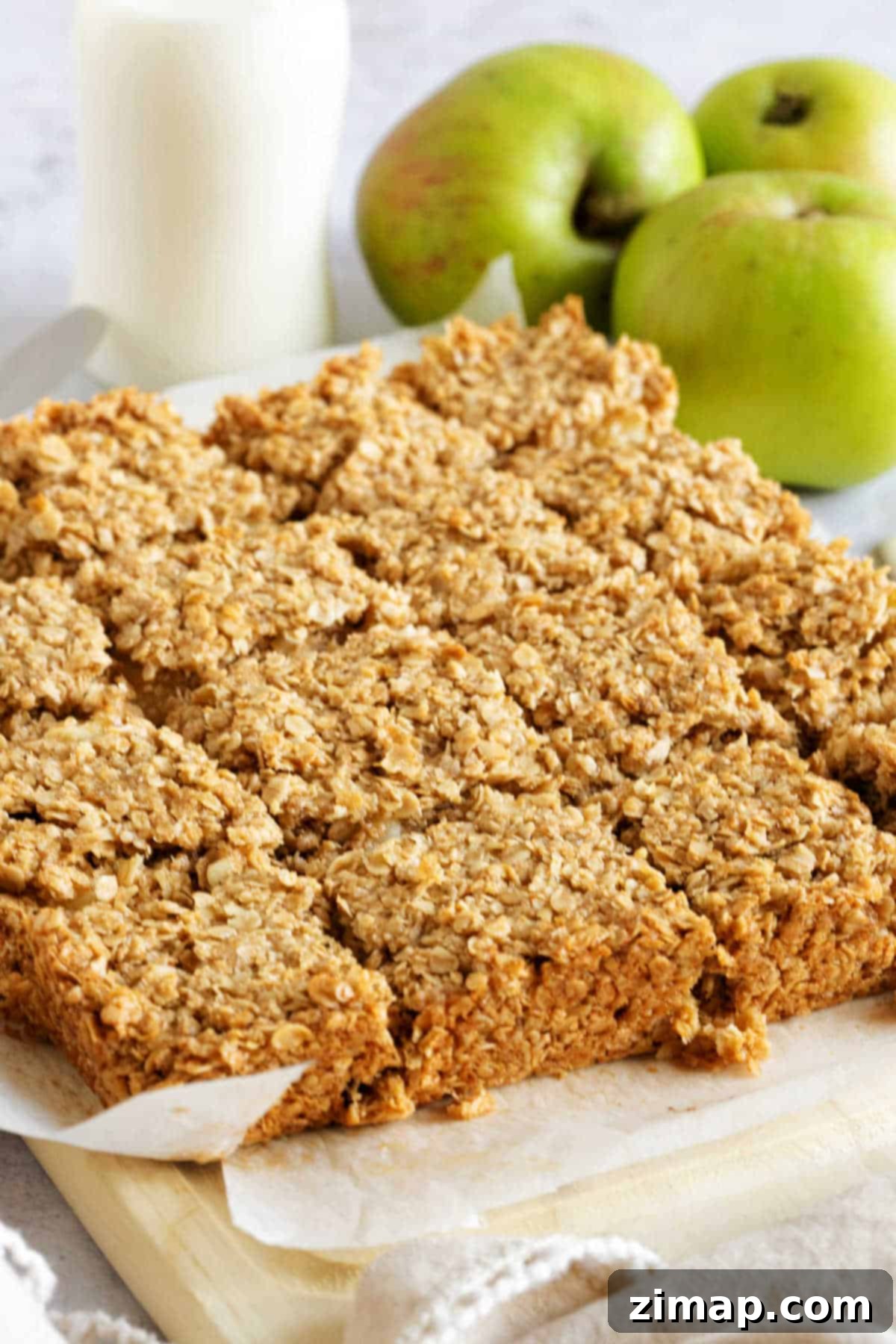 Εύκολες Μηλόμπάρες Βρώμης 5 Flapjacks μήλου σε ξύλινη σανίδα.