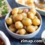 Εύκολες Πατατούλες Φούρνου 6 Roasted baby potatoes in a grey bowl.