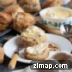 Εύκολη Συνταγή για Σκόουνς με Χουρμάδες και Καρύδια 9 Ένα σκονς με χουρμάδες και καρύδια σε ένα πιάτο με κρέμα.