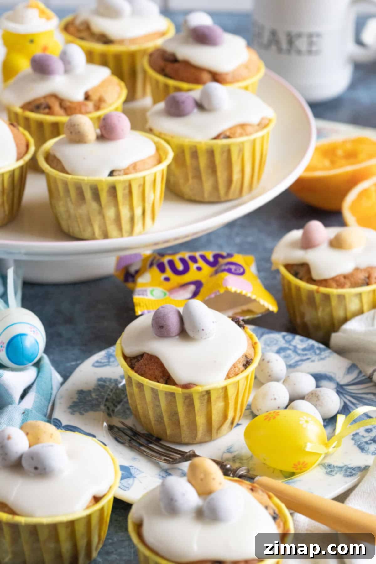 Πασχαλινά Μάφινς 2 Πασχαλινά simnel muffins σε βάση και πιάτο, με Mini Eggs από πάνω.