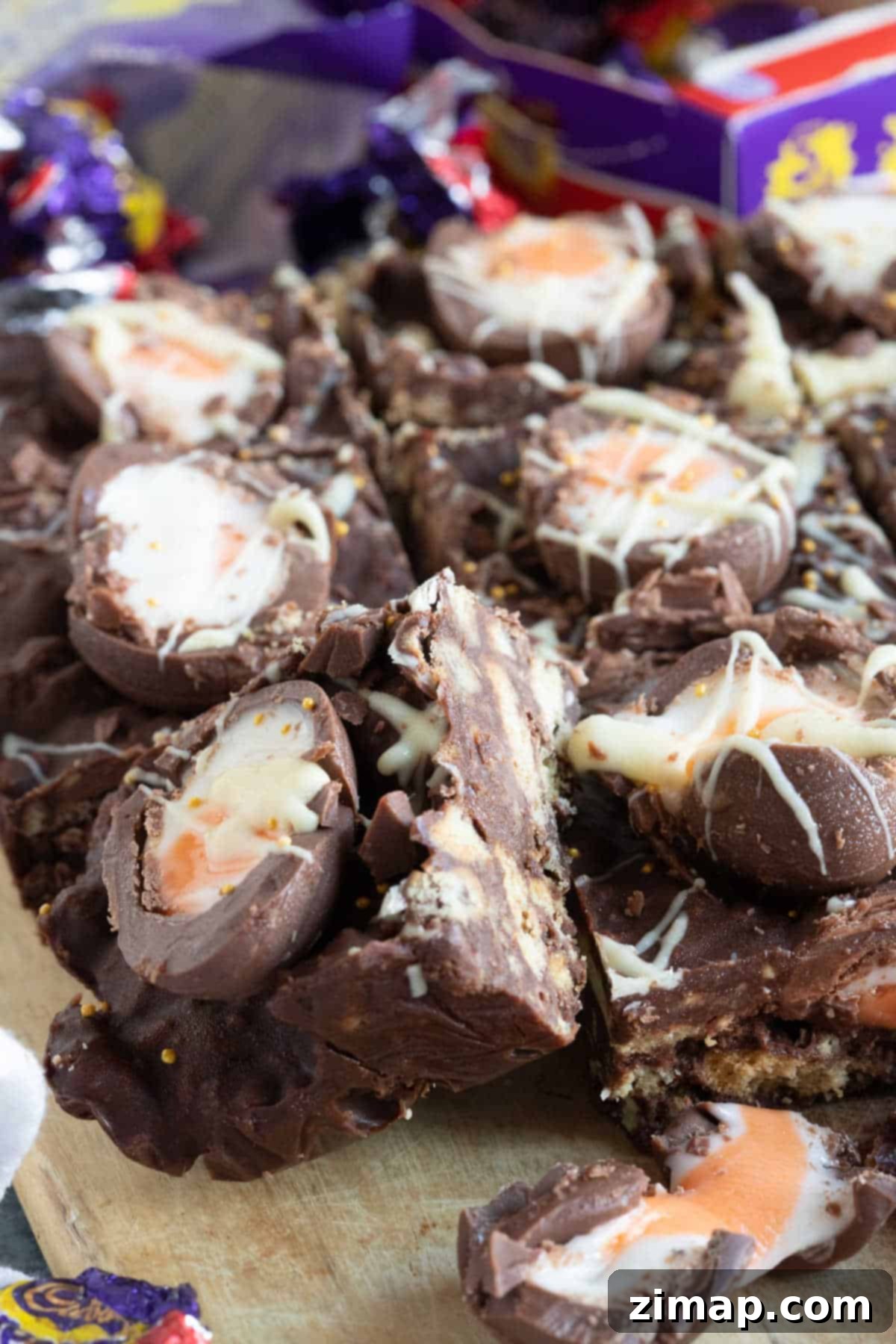 Η Απόλυτη Συνταγή Τίφιν με Αυγά Κρέμας Cadbury 7 Tiffin με Creme Eggs σε μια σανίδα κοπής.