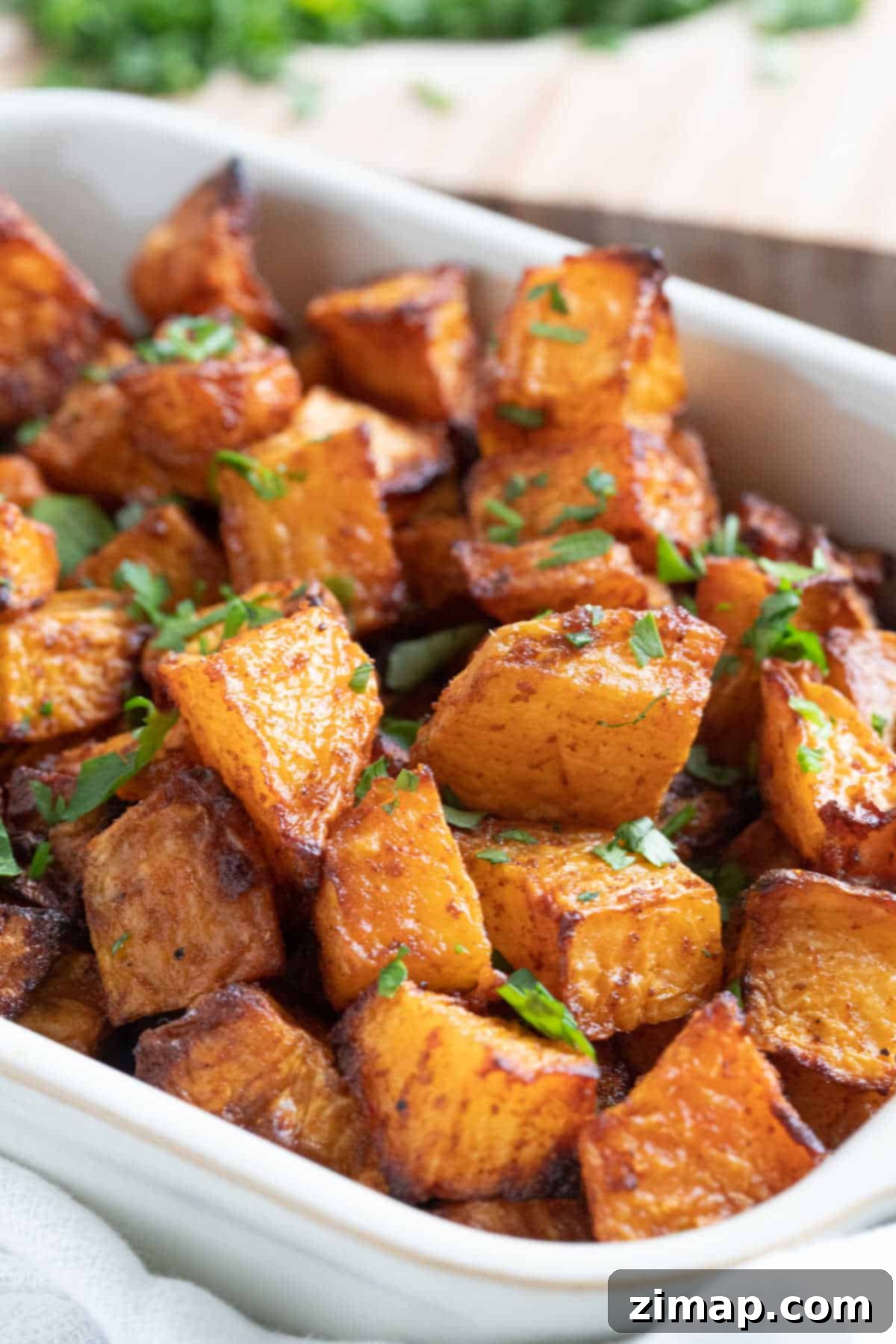 Η Πιο Εύκολη Συνταγή για Ψητό Ρουταμπάγκα 2 Roasted swede in a serving dish garnished with chopped parsley.