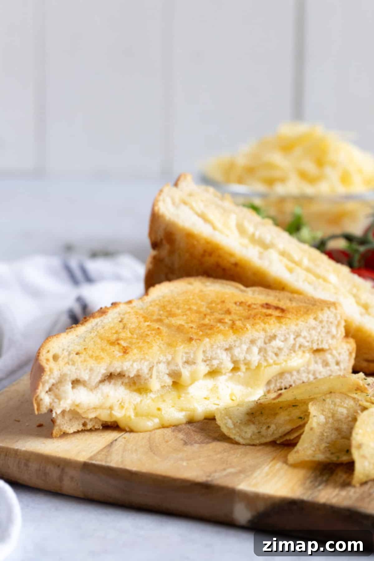 Τραγανό Τοστ Φριτέζας Αέρος 10 Air fryer toasted cheese sandwich on a wooden board.