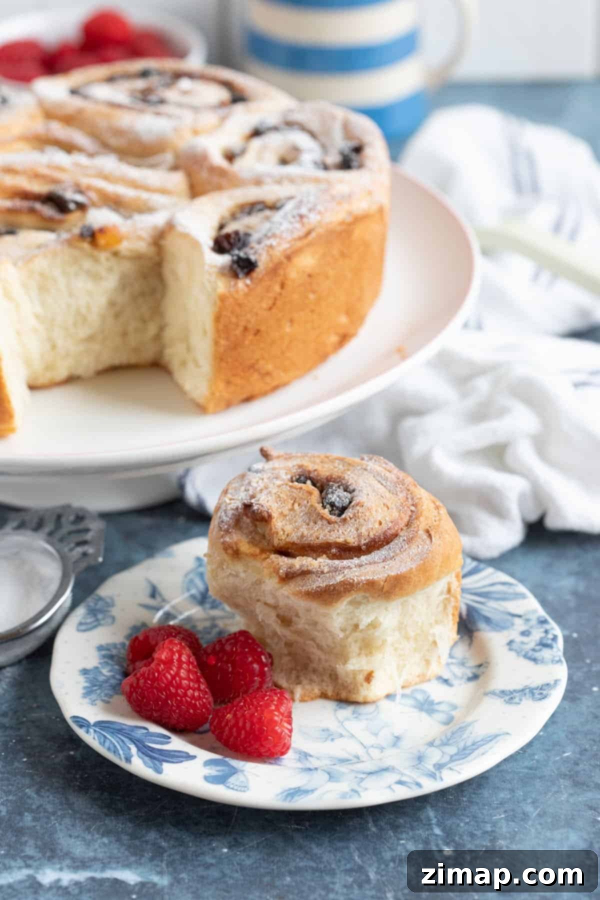 Λαρδοκέικ χωρίς κόπο 9 Lardy cake σε βάση για κέικ, με ένα κομμάτι σε πιάτο.