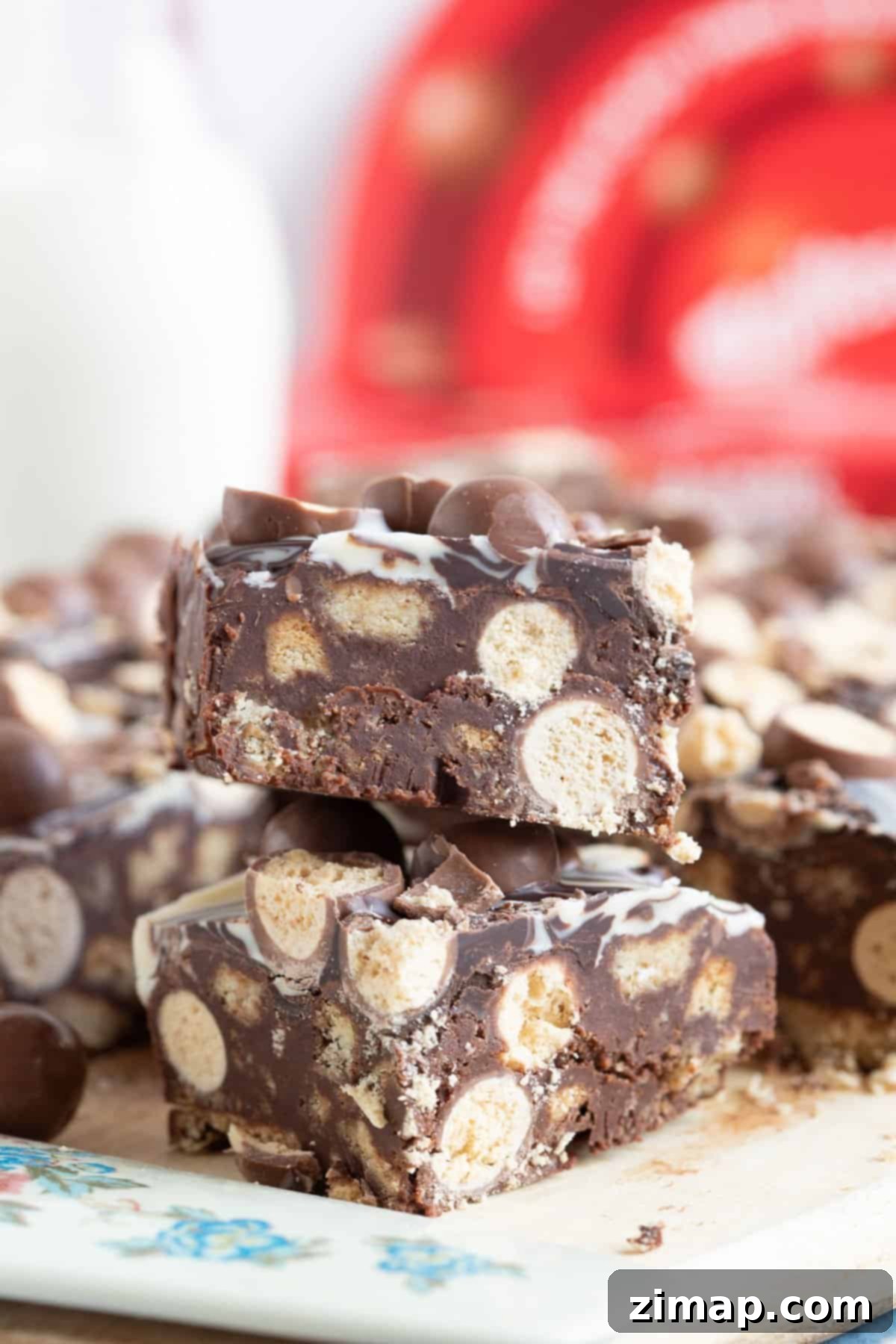 Το Αξεπέραστο Μπισκοτογλυκό Μαλτέζερ 2 Chocolate malteser tiffin bars on a wooden board.