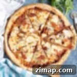 Η Απόλυτη Συνταγή Πίτσας Κοτόπουλου BBQ 9 Πίτσα BBQ κοτόπουλο σε ξύλινη σανίδα.