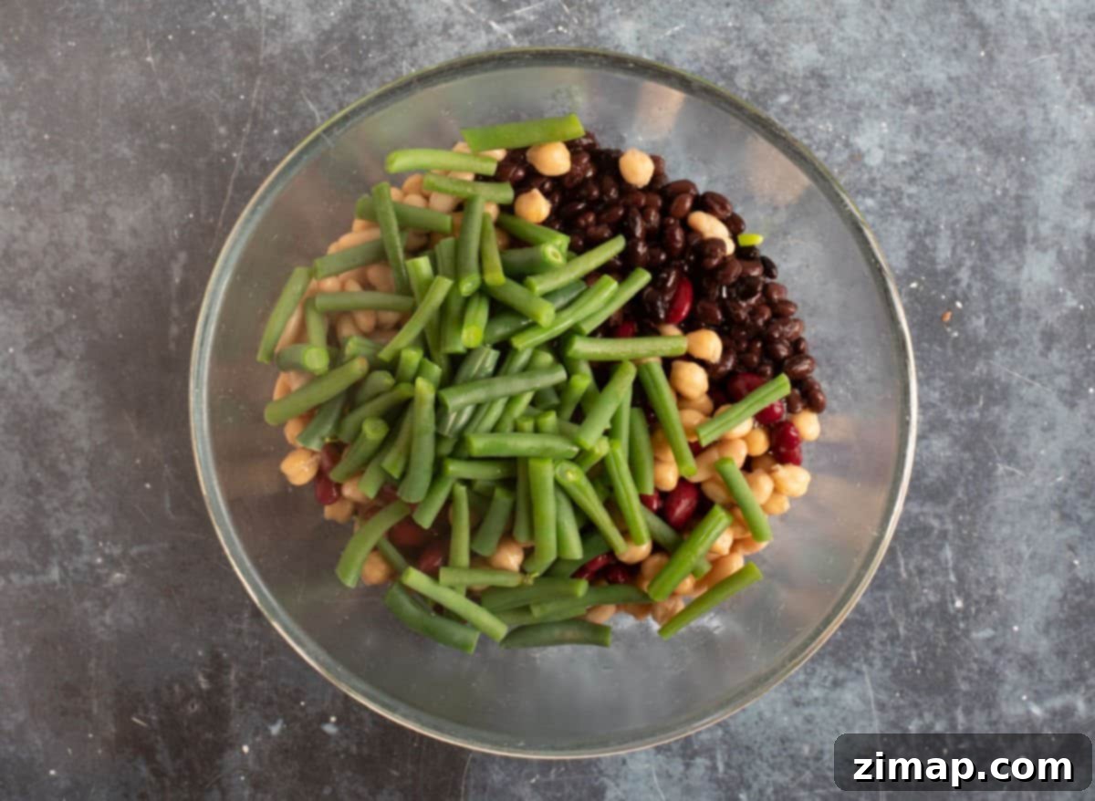 Εύκολη Σαλάτα με Πέντε Φασόλια 5 Green beans added to the canned beans in a bowl.