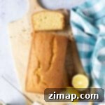 Εύκολη Συνταγή για Κέικ Μαδέιρα 8 Madeira loaf cake on a wooden board with a slice cut.