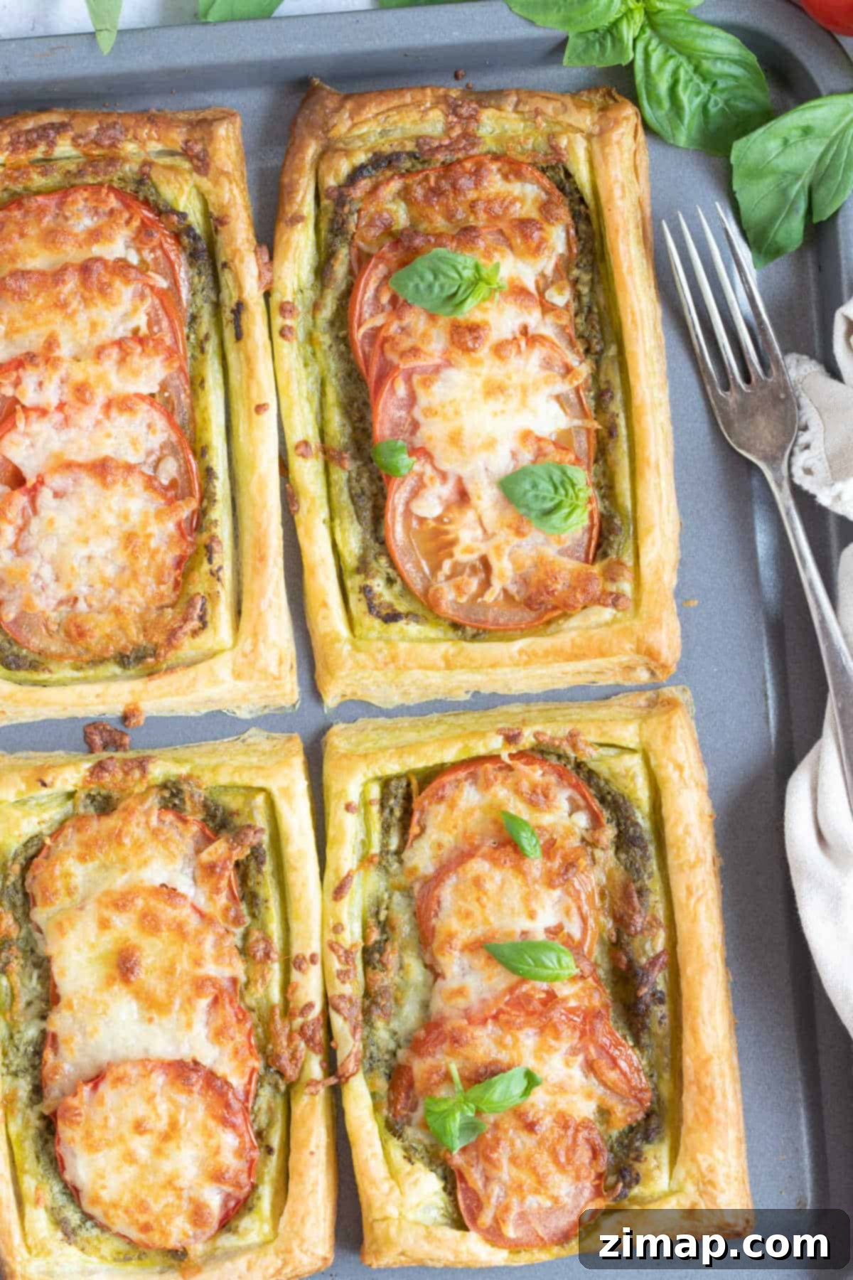Σφολιατοταρτάκια πανεύκολα 5 Savoury puff pastry tarts on a baking tray.