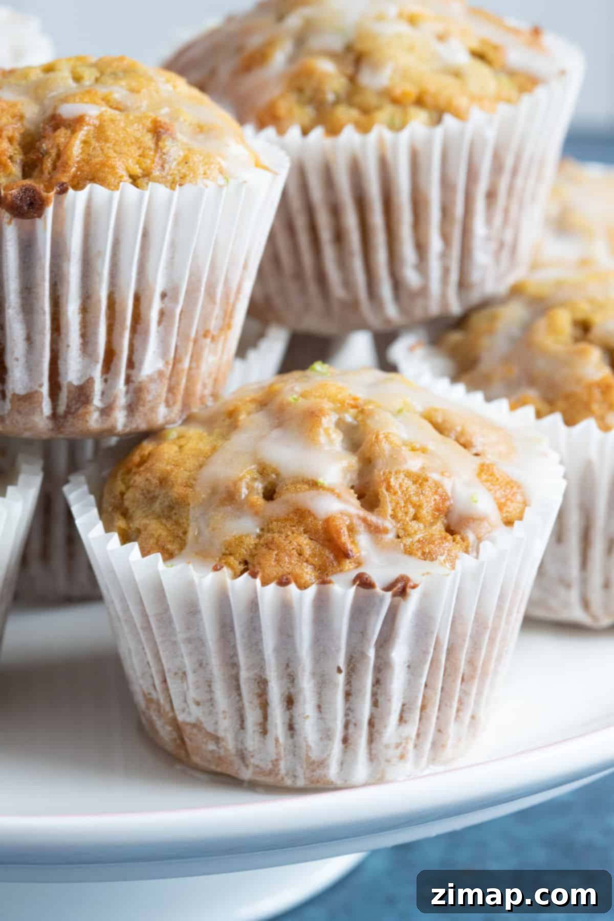 Πανεύκολα Μάφινς Καροτόπιτας 2 Carrot cake muffins on a cake stand.