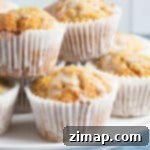 Πανεύκολα Μάφινς Καροτόπιτας 8 Carrot cake muffins on a cake stand.
