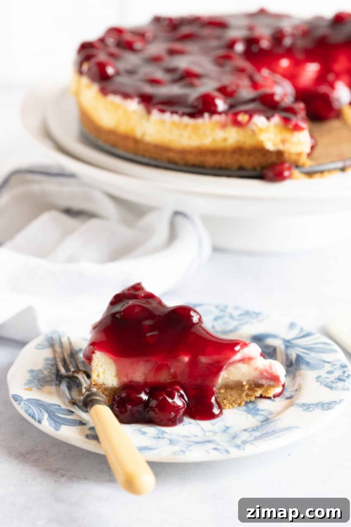 Εύκολο Τσίζκεϊκ με Κεράσια 5 Μια φέτα cheesecake βύσσινο σε πιάτο.