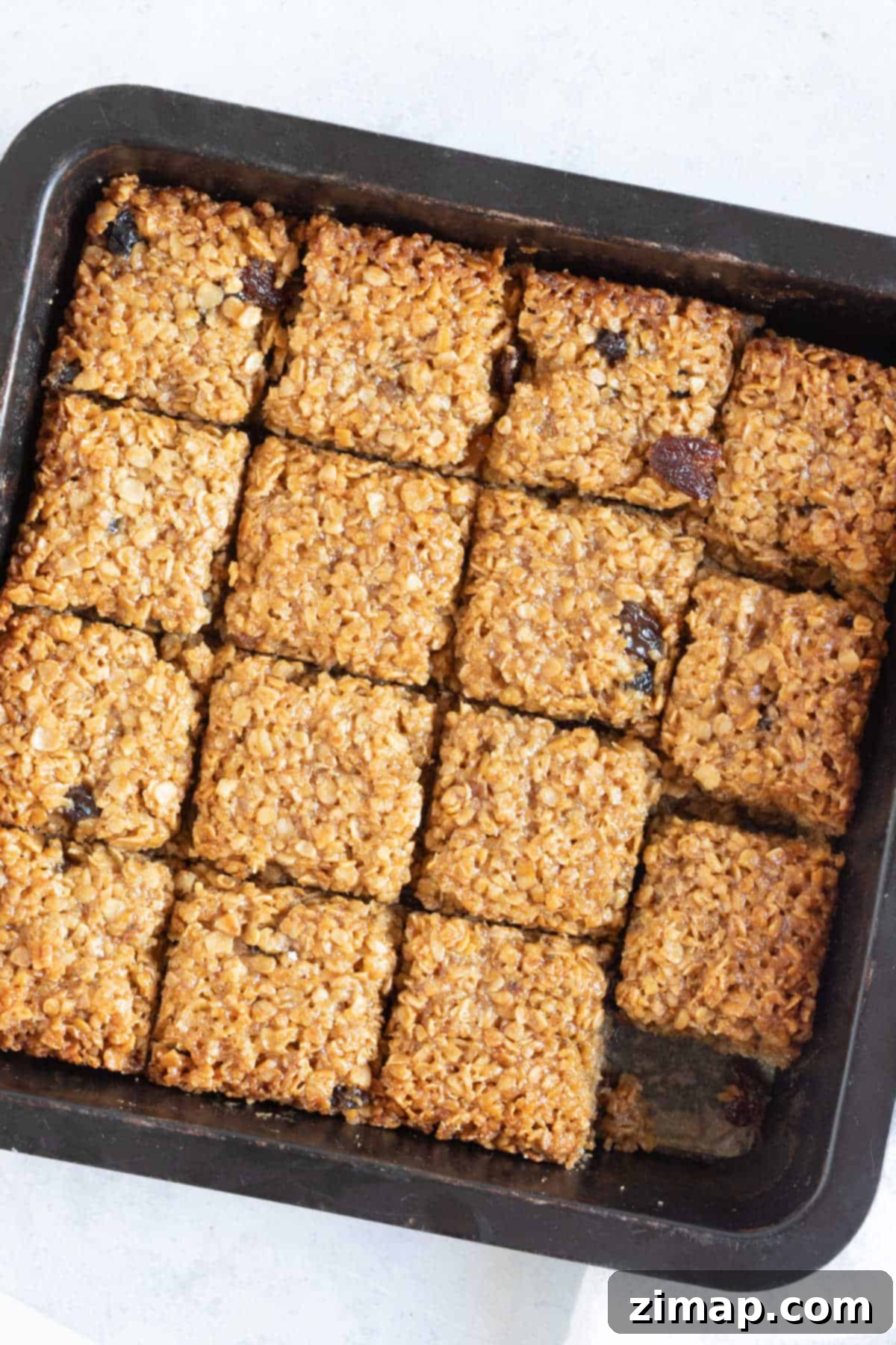 Γρήγορες Μπάρες Βρώμης με Ζουμερά Φρούτα 7 Mincemeat flapjacks in a baking tin.