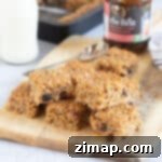Γρήγορες Μπάρες Βρώμης με Ζουμερά Φρούτα 8 Mincemeat flapjacks on a wooden board.