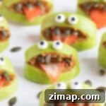 Πράσινα Τερατάκια Μήλου για Υγιεινό Halloween 7 Πράσινα μήλα τέρατα σε ένα λευκό πιάτο.