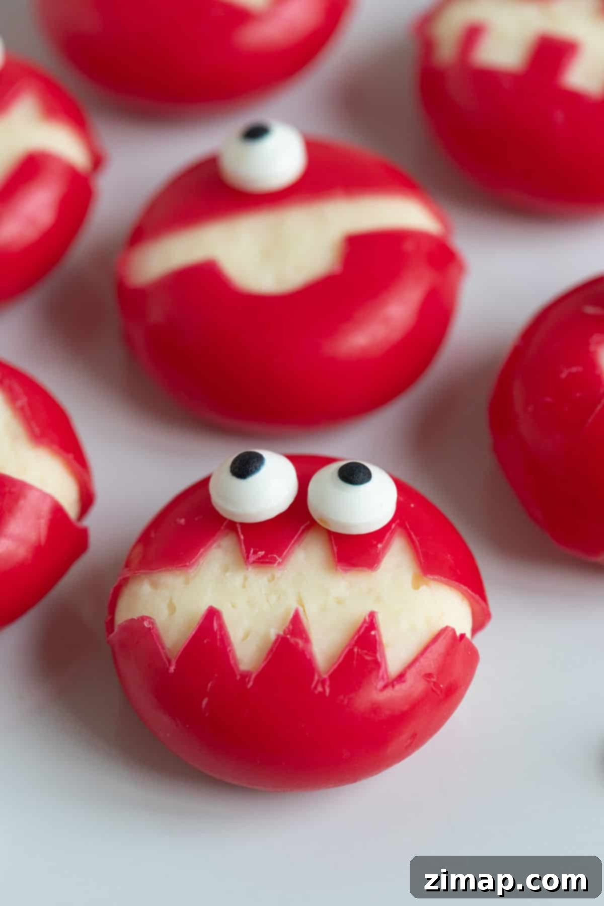 Εύκολα Αποκριάτικα Τερατάκια Babybel 4 Babybel cheese monsters on a plate.