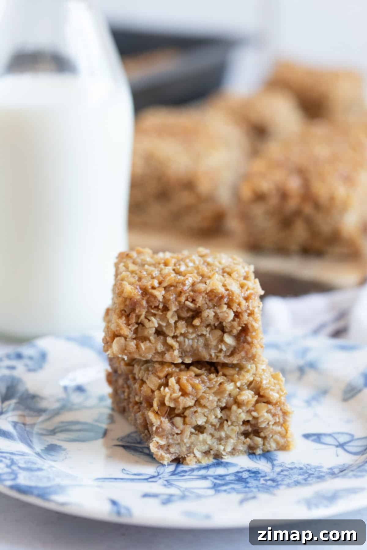 Πανεύκολες Μπάρες Βρώμης 7 Flapjacks σε πιάτο με ένα ποτήρι γάλα.