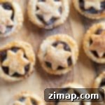 Εύκολη Συνταγή για Ταρτάκια Σφολιάτας με Χριστουγεννιάτικη Γέμιση 8 Μικρές τάρτες κιμά με σφολιάτα σε ξύλινη επιφάνεια.