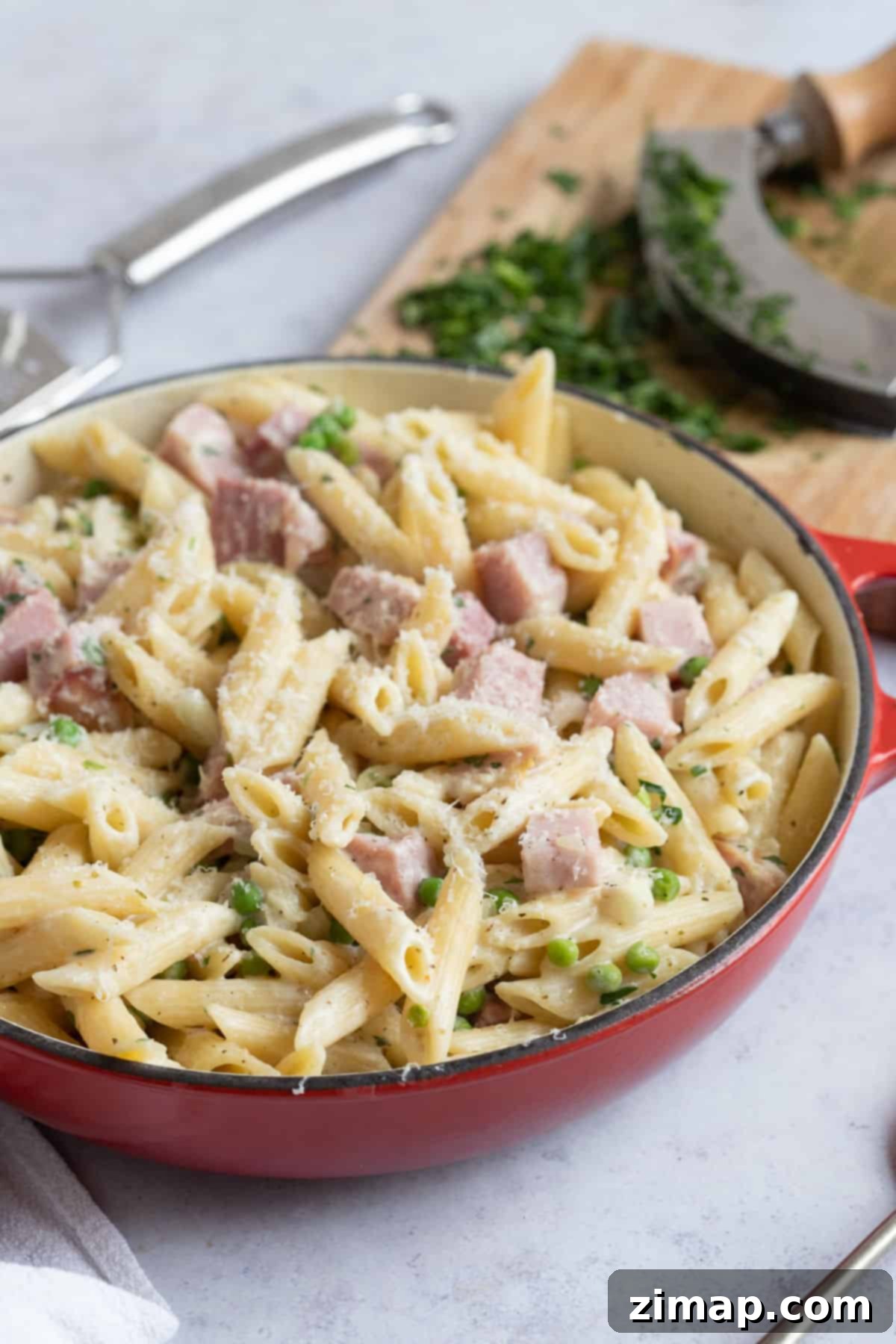 Εύκολα Ζυμαρικά με Περισσεύματα Γκάμον 5 Leftover ham and pea pasta in a red pan.