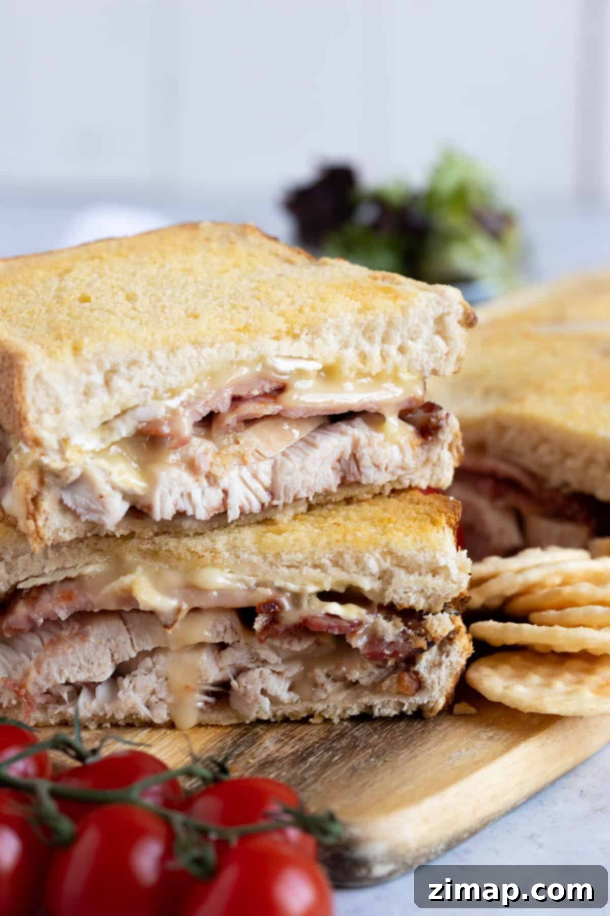 Σάντουιτς γαλοπούλας, μπέικον και μπρι με air fryer σε ξύλινη σανίδα.