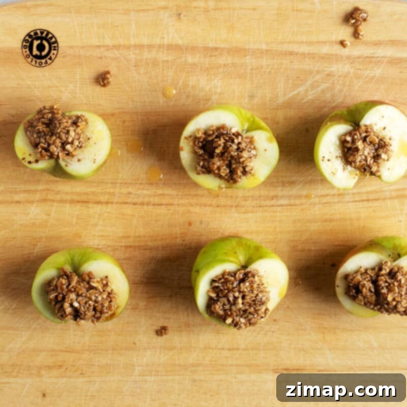 Εύκολα Ψητά Μήλα στη Φριτέζα Αέρος 8 Μήλα με topping crumble σε ξύλινη επιφάνεια.