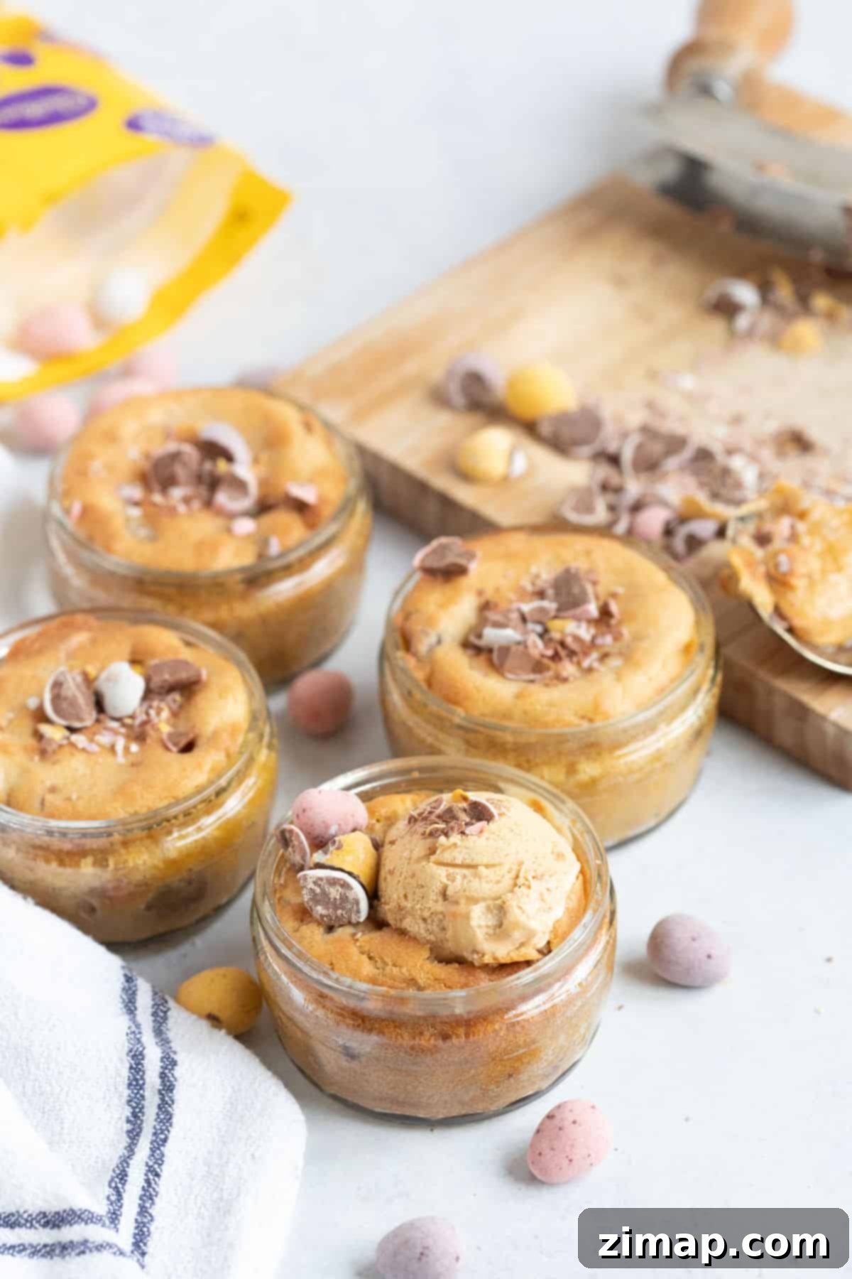 Αυγο-γλυκάκια Αέρος 7 4 mini egg dessert pots in glass ramekins with ice cream and crushed mini eggs.