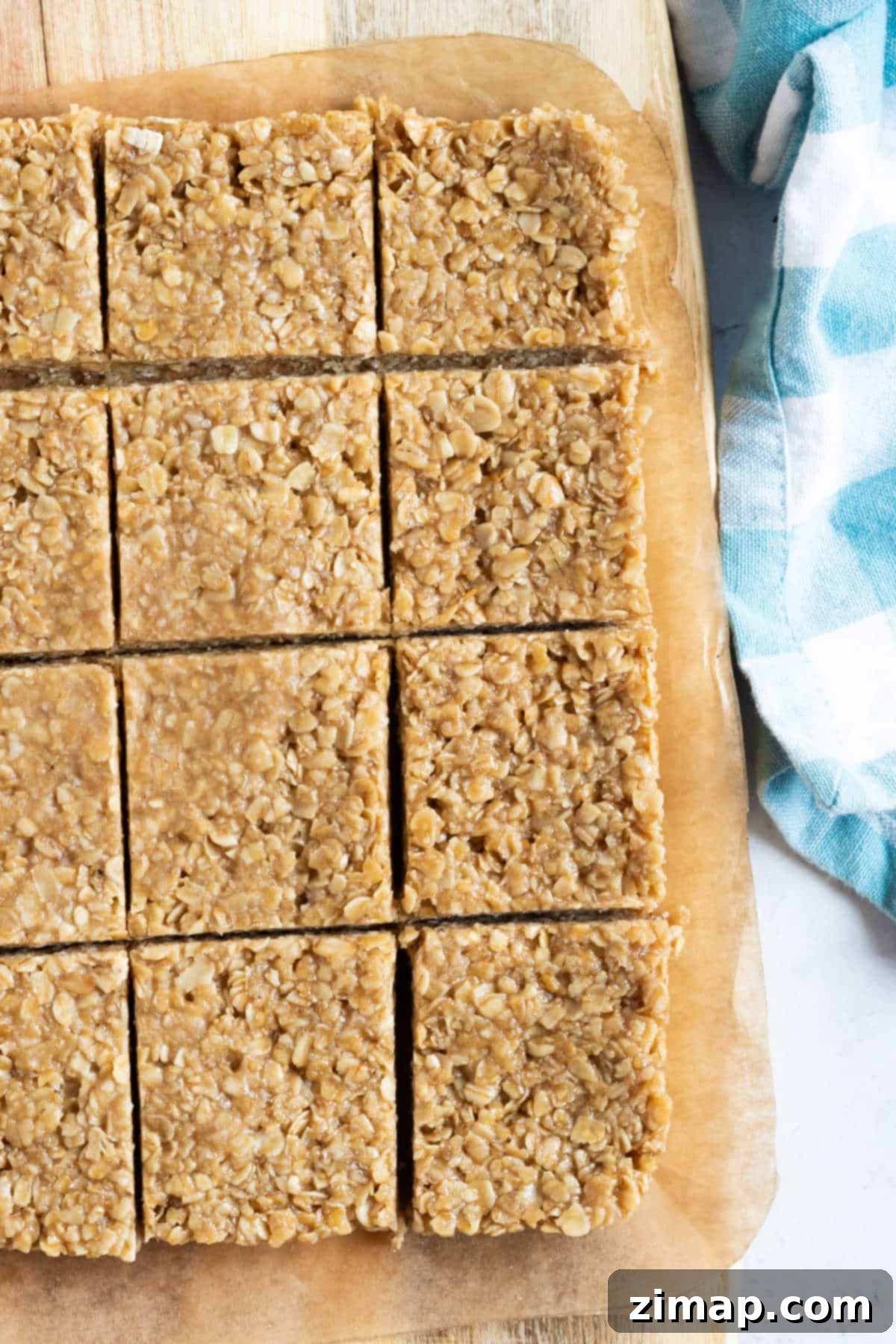 Εύκολες Μπάρες Βρώμης χωρίς Ψήσιμο 6 Flapjacks χωρίς ψήσιμο κομμένα σε τετράγωνα σε ξύλινη επιφάνεια κοπής.