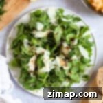 Γρήγορη Σαλάτα Ρόκα με Παρμεζάνα 8 Σαλάτα ρόκας με νιφάδες παρμεζάνας σε λευκό πιάτο.