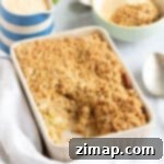 Εύκολο Κράμπλ Μήλου στο Air Fryer 13 Apple crumble σε φριτέζα αέρος με μια κανάτα κρέμας κάσταρντ.