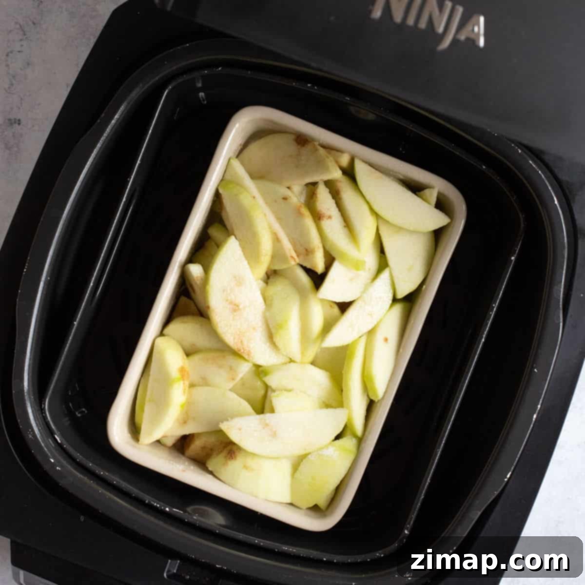 Εύκολο Κράμπλ Μήλου στο Air Fryer 6 Κομμένα μήλα σε φριτέζα αέρος.