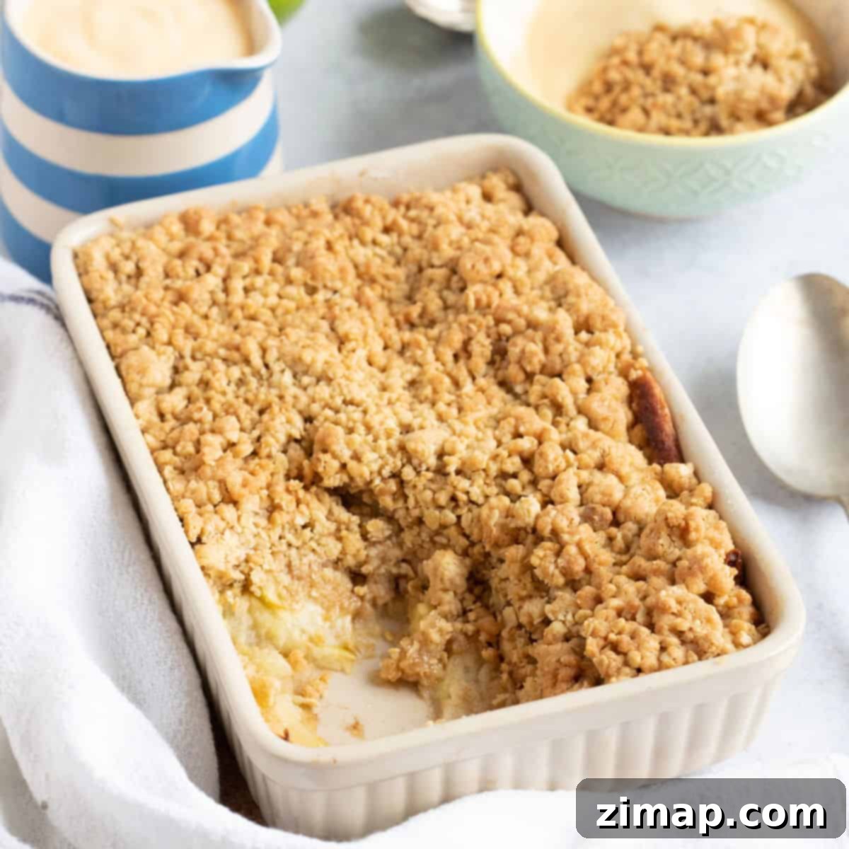 Εύκολο Κράμπλ Μήλου στο Air Fryer 8 Ψημένο apple crumble με μια κανάτα κρέμας κάσταρντ.