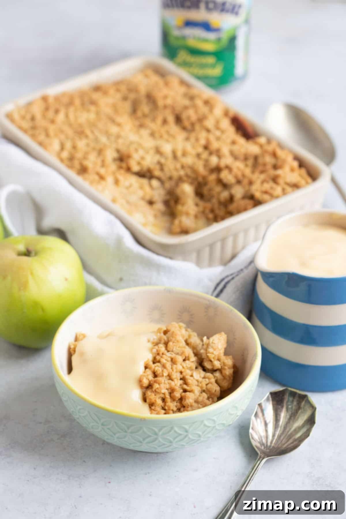 Εύκολο Κράμπλ Μήλου στο Air Fryer 10 Ένα μπολ με apple crumble και κρέμα κάσταρντ.