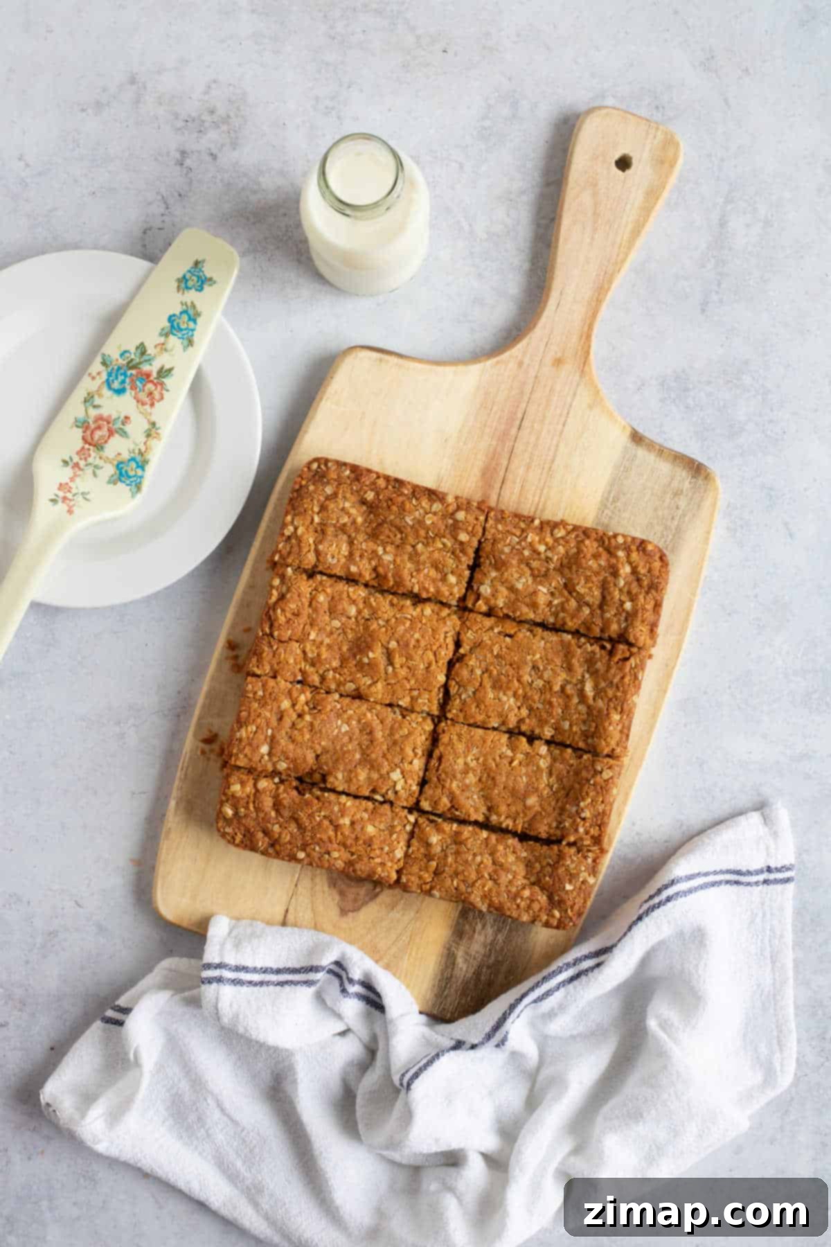 Εύκολη Συνταγή Anzac Slice 8 Μπάρες Anzac σε ξύλινη επιφάνεια.