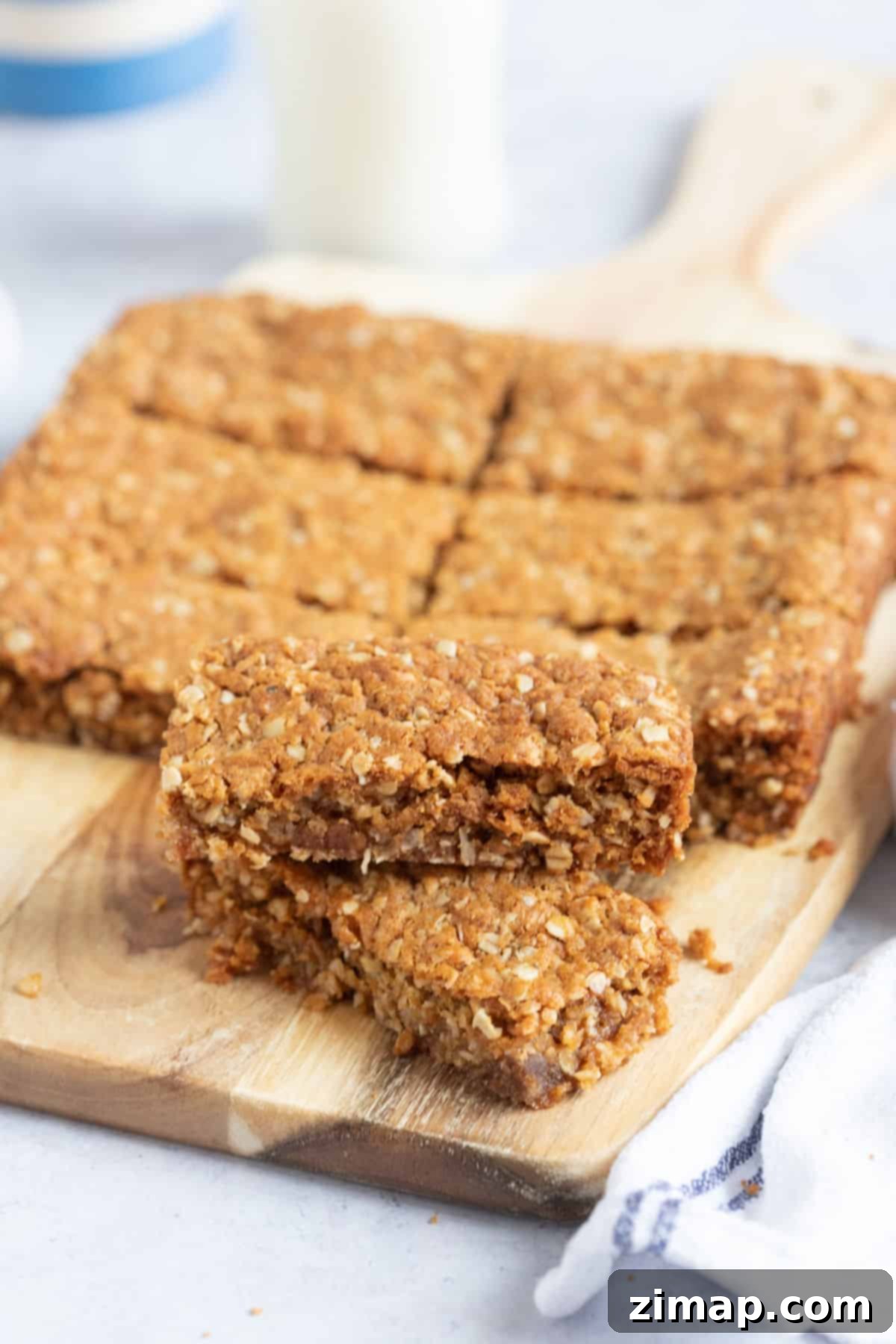 Εύκολη Συνταγή Anzac Slice 7 Μπάρες Anzac σε σανίδα κοπής.