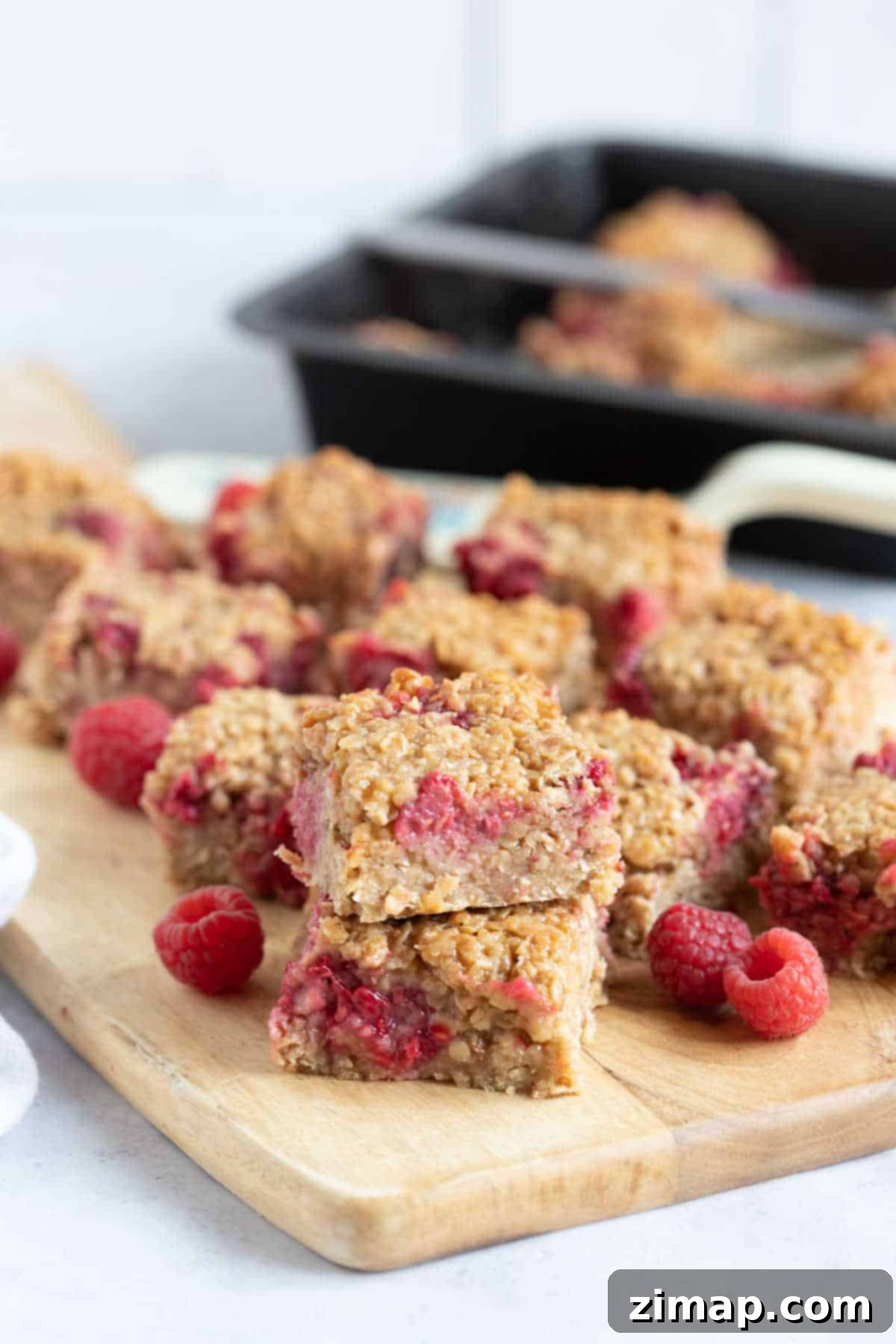 Raspberry flapjacks on a wooden board.