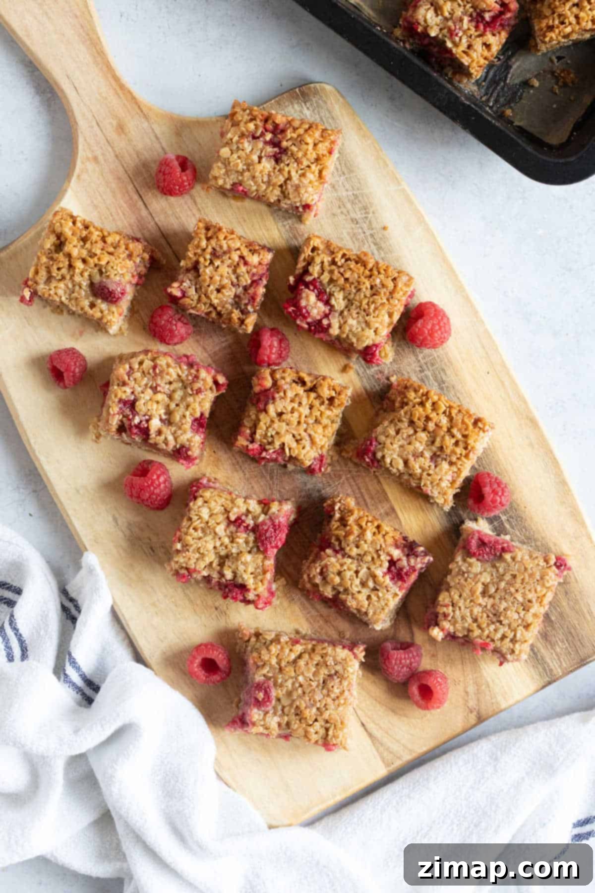 Οι Πιο Εύκολες Μπάρες Βρώμης με Σμέουρα 7 Raspberry Oat Bars on a serving board.