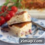 Άζυμη Κις Λορέν Φριτέζας Αέρος 9 Φέτες Κις Λορέν χωρίς κρούστα από φριτέζα αέρος σε ένα μπλε και άσπρο πιάτο.