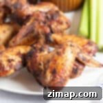 Καυτερές και Τραγανές Φτερούγες Κοτόπουλου Αέρος 9 Τραγανές φτερούγες κοτόπουλου στη φριτέζα αέρος σε πιάτο.