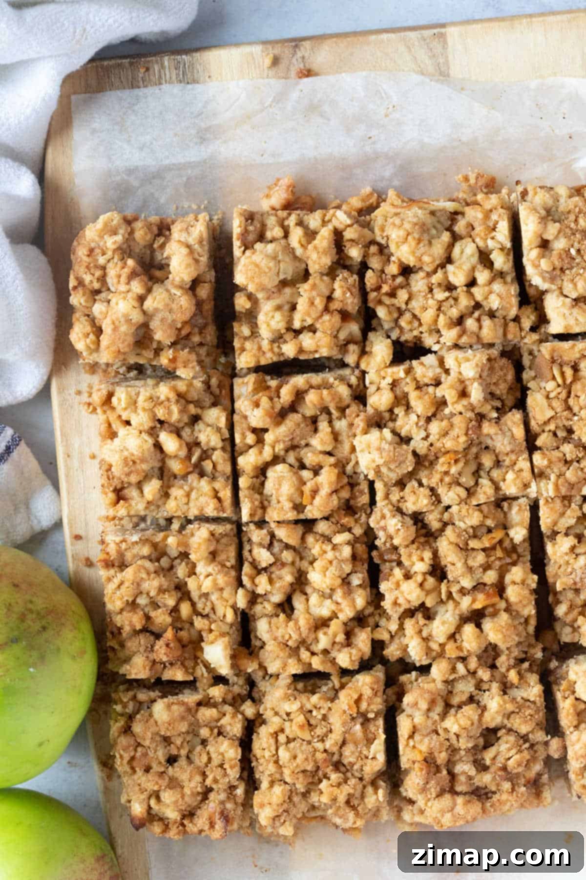 Μπάρες Μήλου και Biscoff Τριφτές 5 Μπάρες μήλου crumble κομμένες σε φέτες σε ξύλινη επιφάνεια.