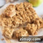 Μπάρες Μήλου και Biscoff Τριφτές 8 Μπάρες μήλου crumble κομμένες σε φέτες σε ξύλινη επιφάνεια.