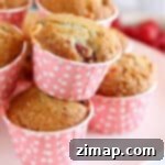 Εύκολα Μάφιν με Σμέουρα και Λευκή Σοκολάτα 6 Μάφινς με σμέουρα και λευκή σοκολάτα σε μια λευκή βάση για κέικ.