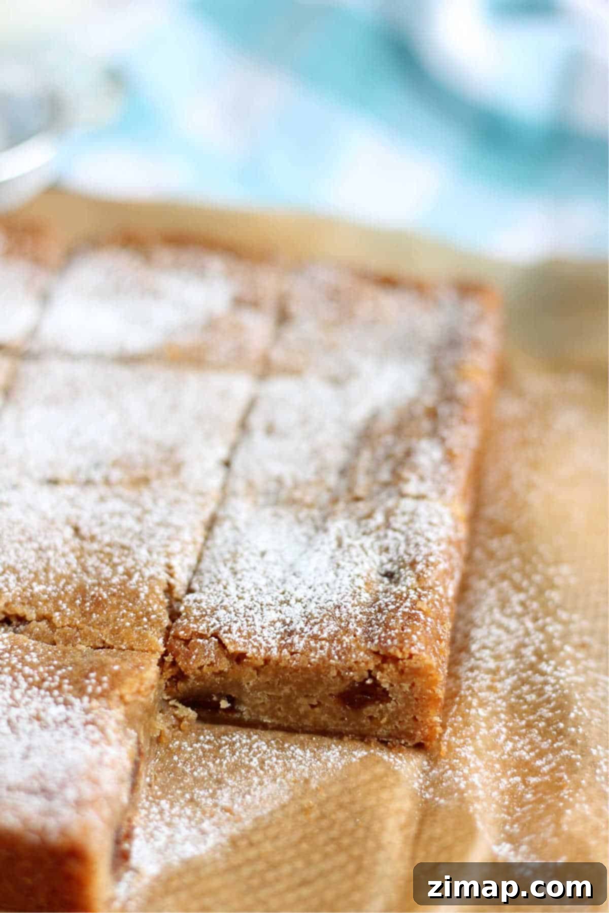 Μπλόουντις Φρουτόπιτας 4 Mincemeat blondies σε ξύλο κοπής, έτοιμα να κοπούν σε φέτες.