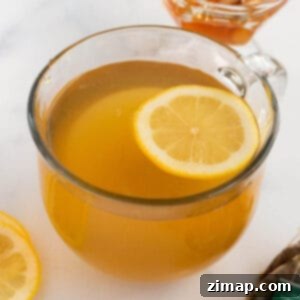 Σταρμπάκς Μέντισιν Μπολ Τσάι 8 Μια διαφανής κούπα καφέ με κεχριμπαρένιο τσάι και μια φέτα λάιμ στην κορυφή.
