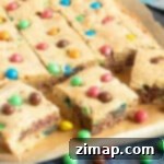 M&M Μπισκοτομπάρες με Τσιπς Σοκολάτας 7 Κομμένες μπάρες μπισκότων M&M σε φέτες σε ένα δίσκο.