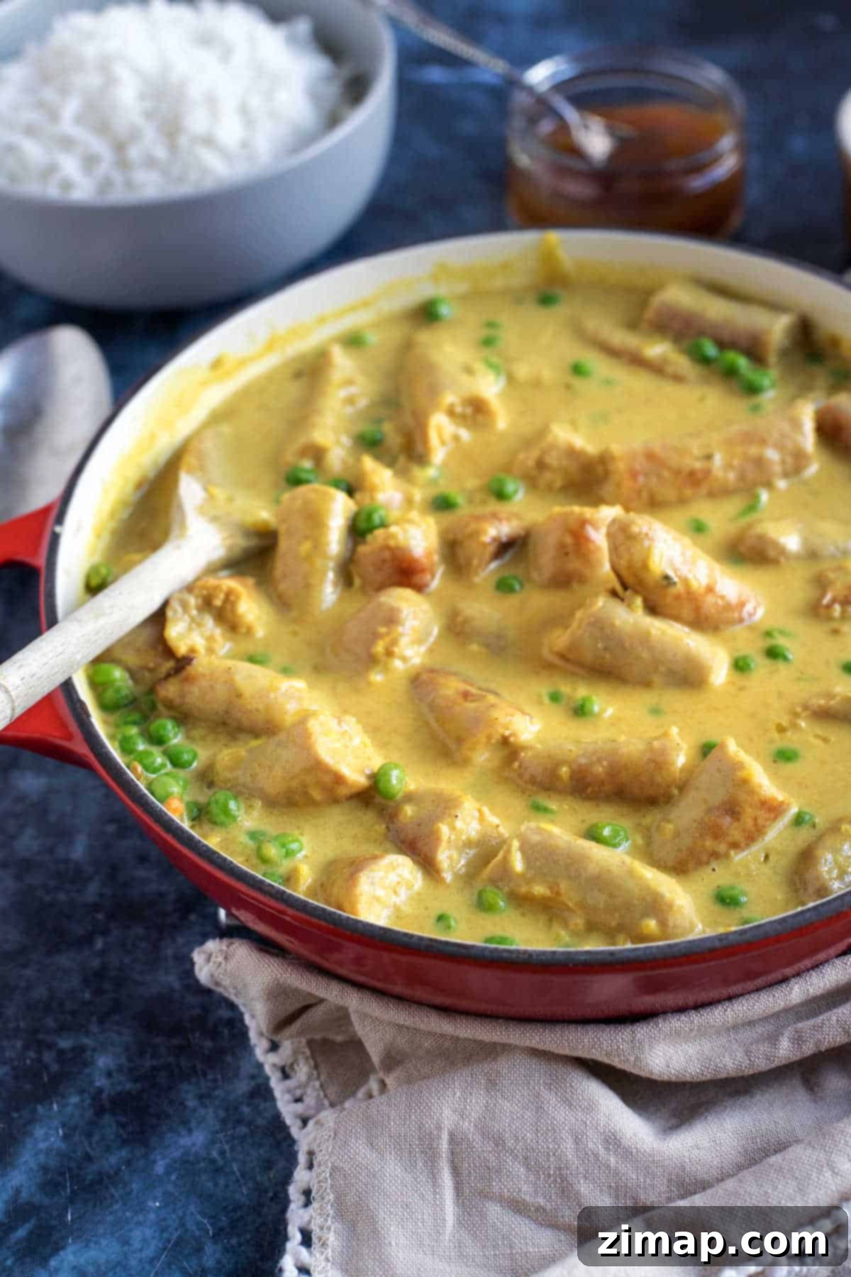 Εύκολο Κάρυ με Λουκάνικα 2 Sausage curry in a red pan.
