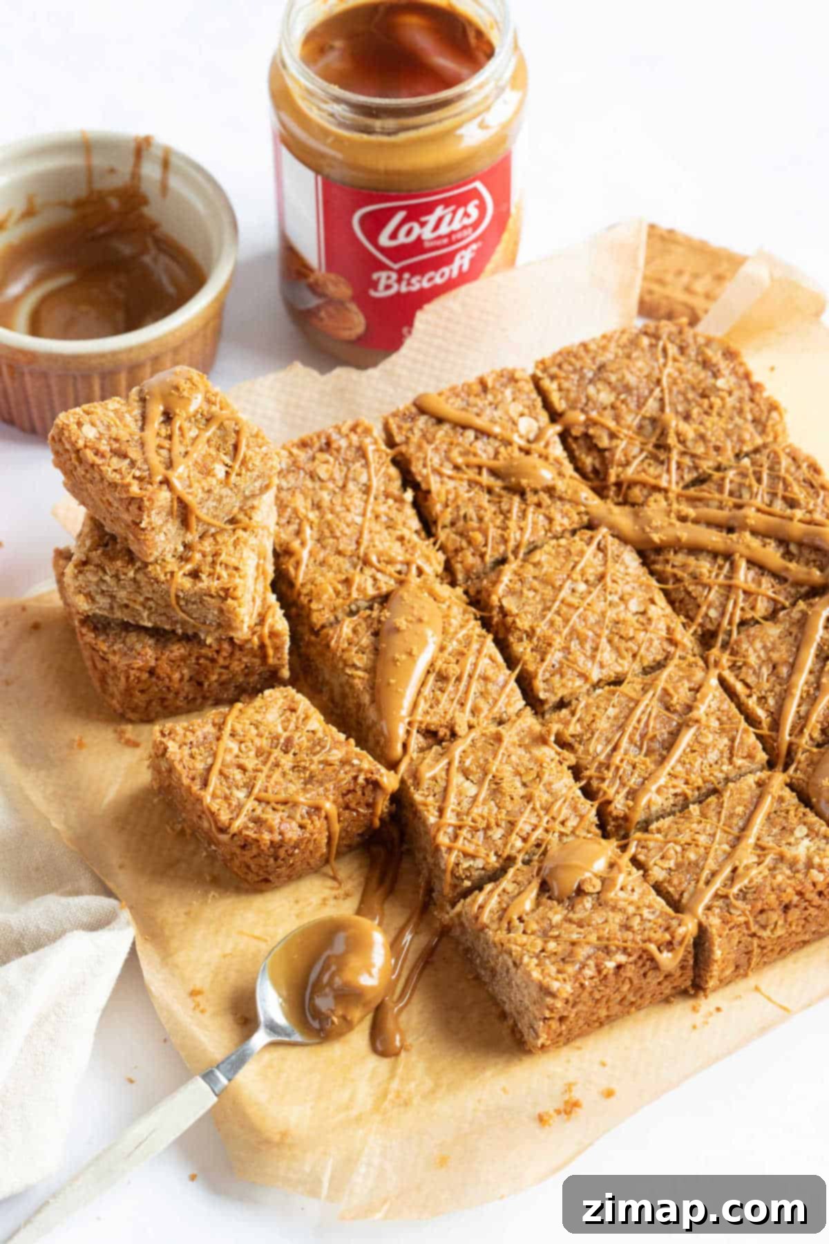 Συνταγή για Μπάρες Βρώμης Λότους Μπίσκοφ 2 Biscoff flapjacks κομμένα σε τετράγωνα και περιχυμένα με περισσότερη κρέμα Biscoff.