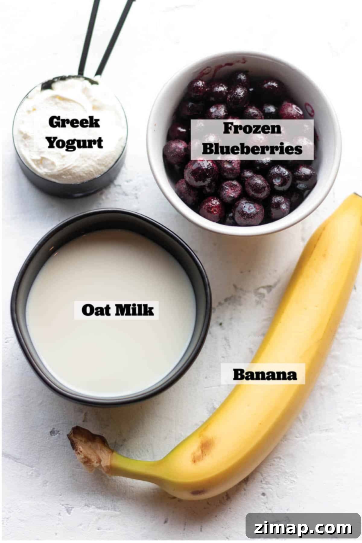Μύρτιλο Σμούθι Μπολ 3 Ελληνικό γιαούρτι, γάλα βρώμης, μπανάνα και ένα μπολ με μύρτιλα.